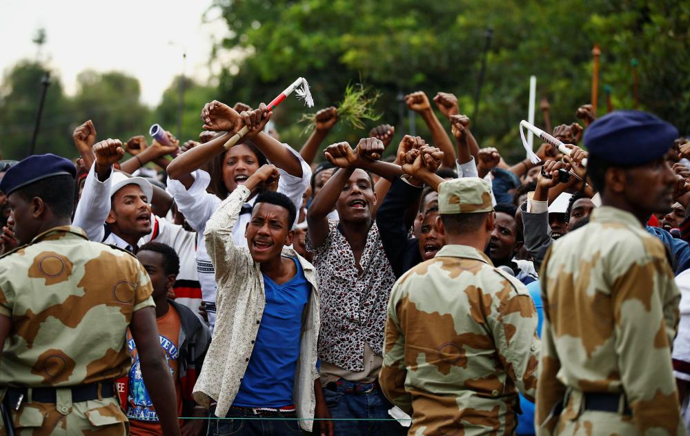 Demonstrators chant slogans while flashing the Oromo protest gesture during Irreecha, the thanksgiving festival of the Oromo people, in Bishoftu town, Oromia, on 2 October 2016.